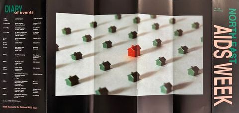 A colour photograph of a flyer advertising North East AIDS Week, May 1992. The flyer features a photograph  of a Monopoly game pieces, with one piece representing a person with AIDS. The flyer includes information about the events taking place during the week, including a candlelit vigil, a performance by the Promo Afros Homos.