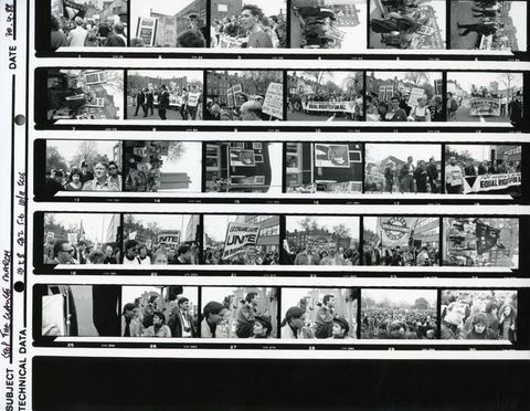 Black and white photograph. Series of 30 photographs on a contact sheet. Protestors and police at the 1988 Stop the Clause March. Groups of people hold banners with text in capitalised letters, including "EQUAL RIGHTS FOR ALL".